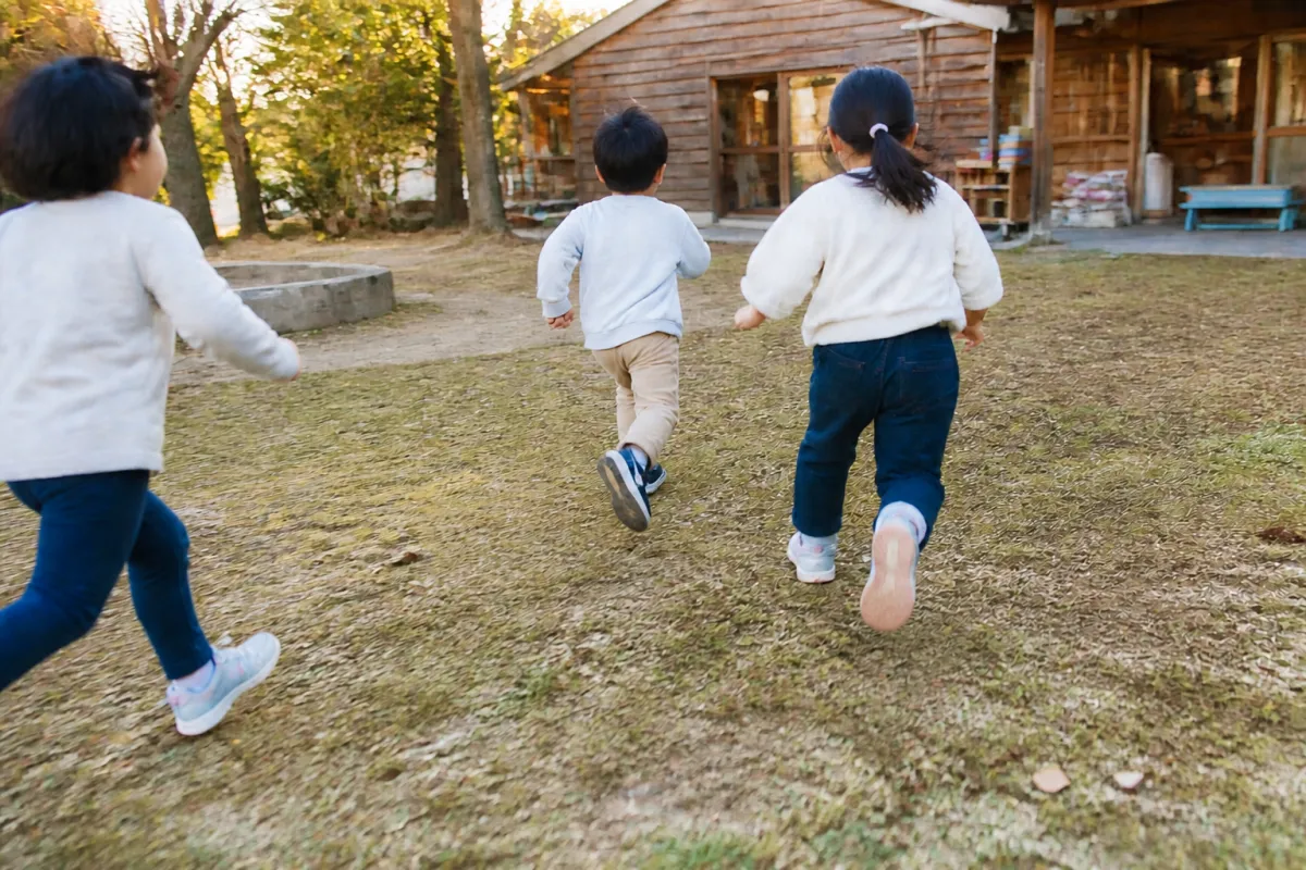 園庭を走る子どもたちの後ろ姿
